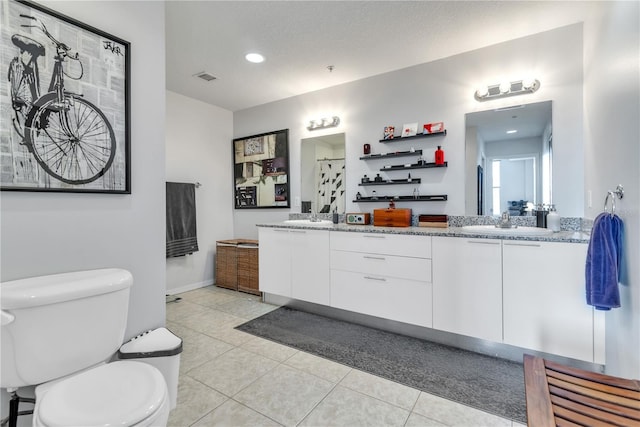 bathroom featuring tile patterned flooring, vanity, toilet, and a textured ceiling