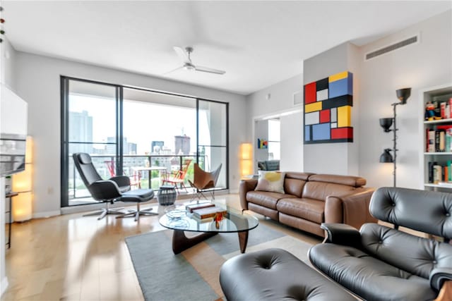 living room with light wood-type flooring and ceiling fan