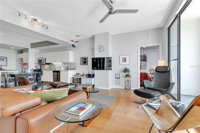 living room featuring ceiling fan and light wood-type flooring