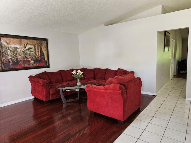 living room featuring lofted ceiling, a textured ceiling, and tile floors