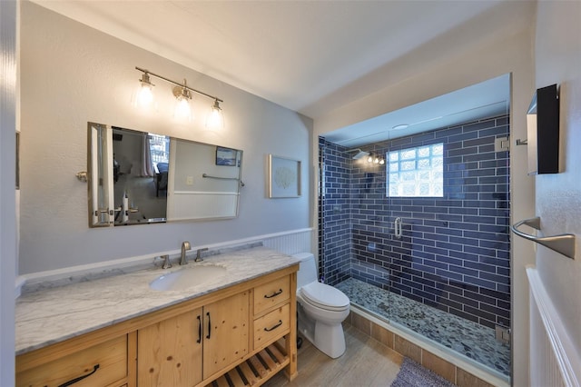 bathroom featuring vanity, hardwood / wood-style floors, a shower with shower door, and toilet