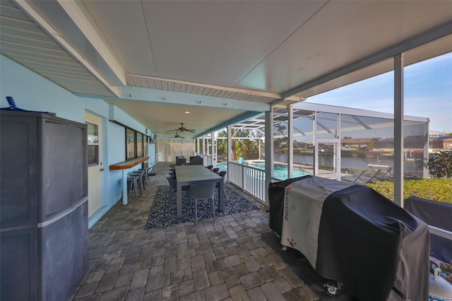 view of patio / terrace with ceiling fan, a water view, a grill, and glass enclosure