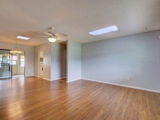 unfurnished room featuring ceiling fan, hardwood / wood-style floors, and a textured ceiling