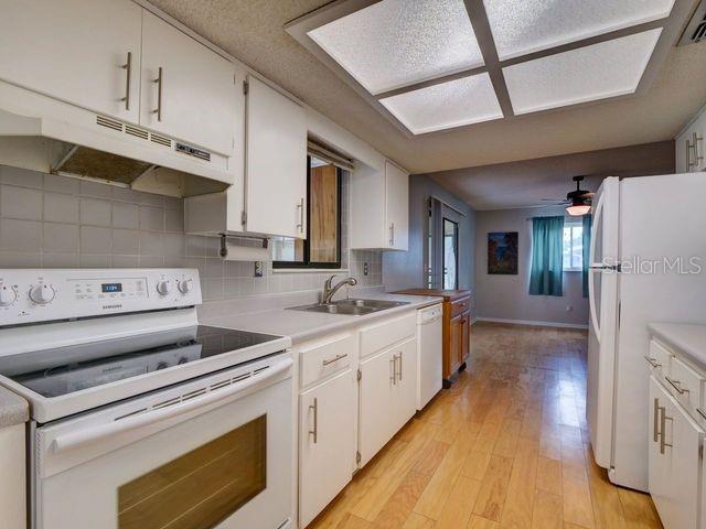 kitchen featuring white cabinetry and white appliances