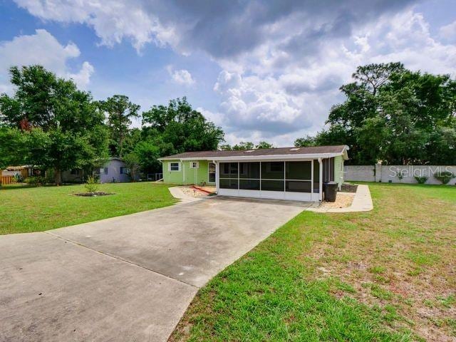 view of front of property featuring a sunroom and a front yard