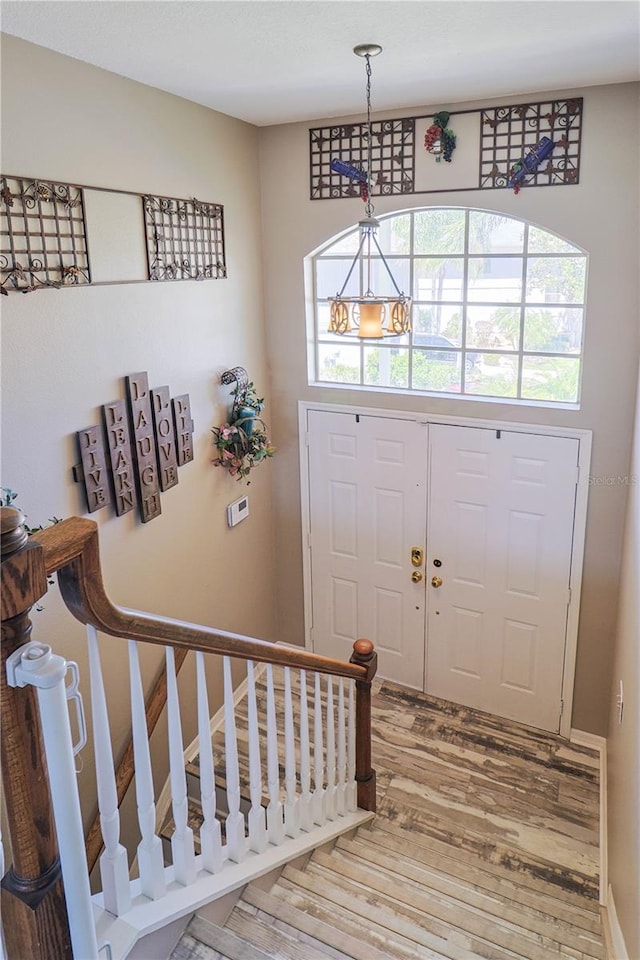 foyer with a chandelier and wood-type flooring