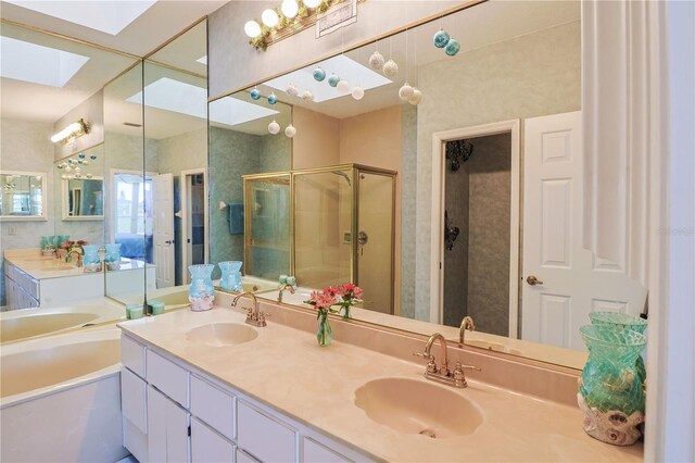 bathroom with a skylight, independent shower and bath, oversized vanity, and dual sinks