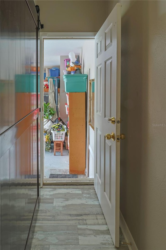 hallway with light hardwood / wood-style floors