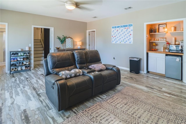 living room with light hardwood / wood-style floors and ceiling fan