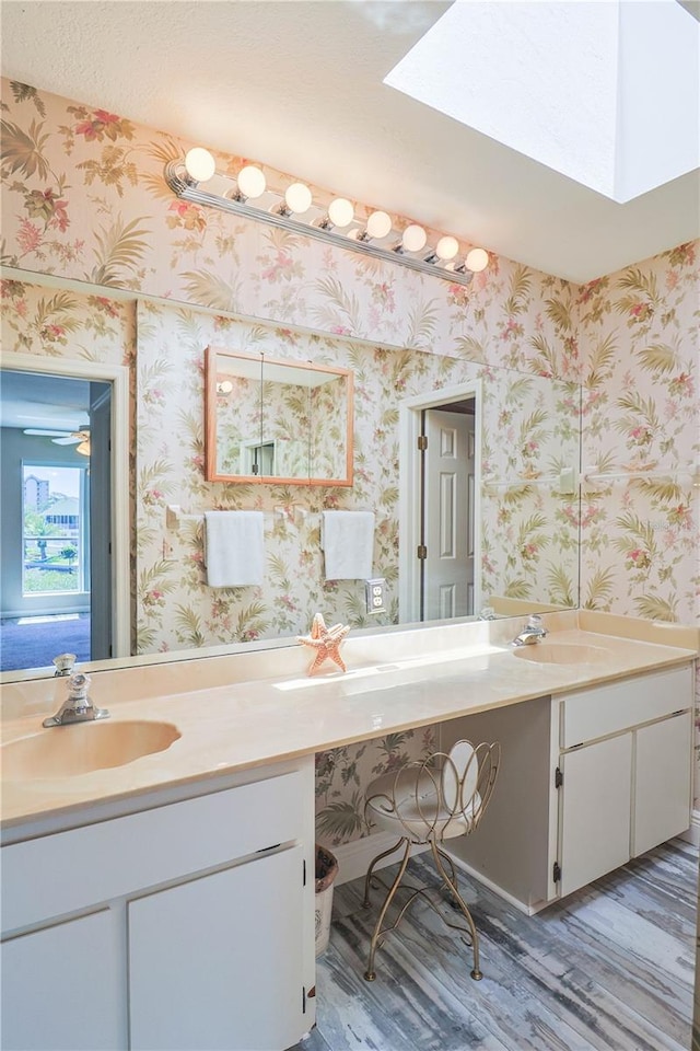 bathroom with ceiling fan, hardwood / wood-style flooring, and double vanity