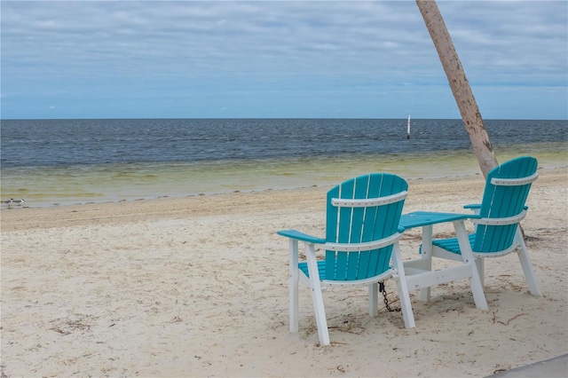 surrounding community with a water view and a view of the beach