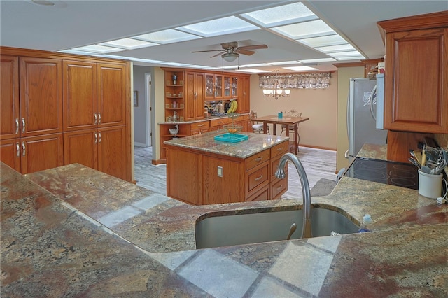 kitchen featuring a kitchen island, light hardwood / wood-style floors, ceiling fan, and fridge