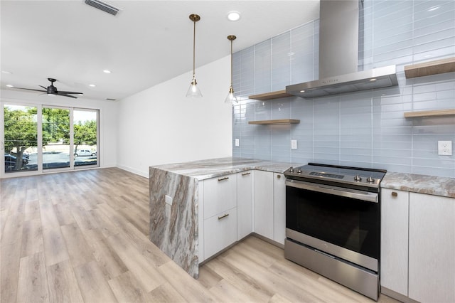 kitchen with stainless steel electric range, wall chimney range hood, ceiling fan, light hardwood / wood-style floors, and white cabinetry