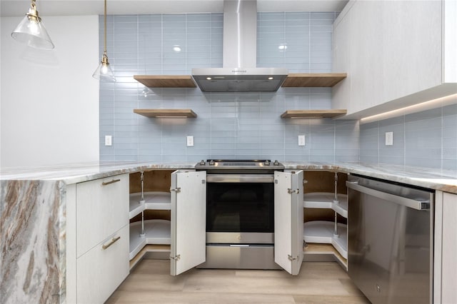 kitchen featuring wall chimney exhaust hood, decorative backsplash, light wood-type flooring, appliances with stainless steel finishes, and decorative light fixtures