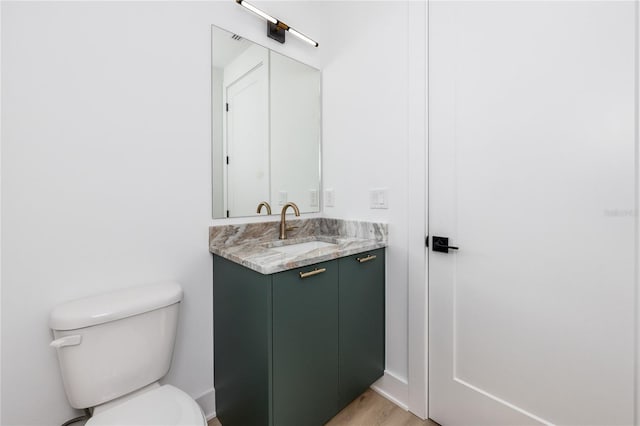 bathroom with vanity, wood-type flooring, and toilet