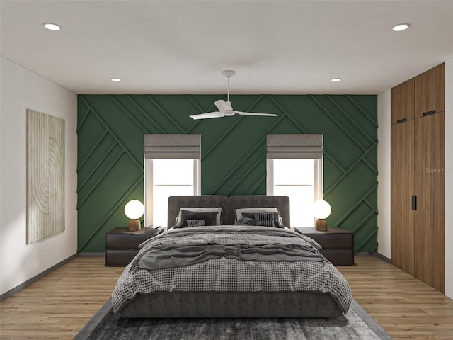 bedroom with light hardwood / wood-style flooring, ceiling fan, and multiple windows