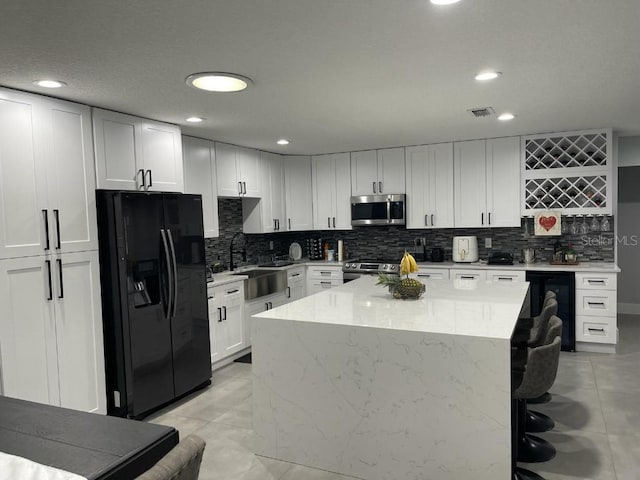 kitchen featuring white cabinets, sink, tasteful backsplash, and stainless steel appliances