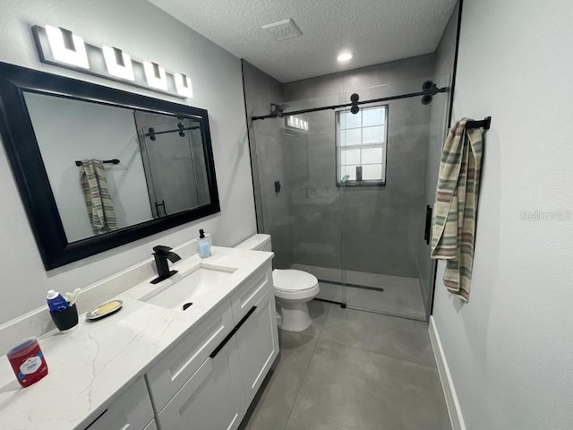 bathroom featuring a textured ceiling, tile floors, toilet, a shower with shower door, and vanity