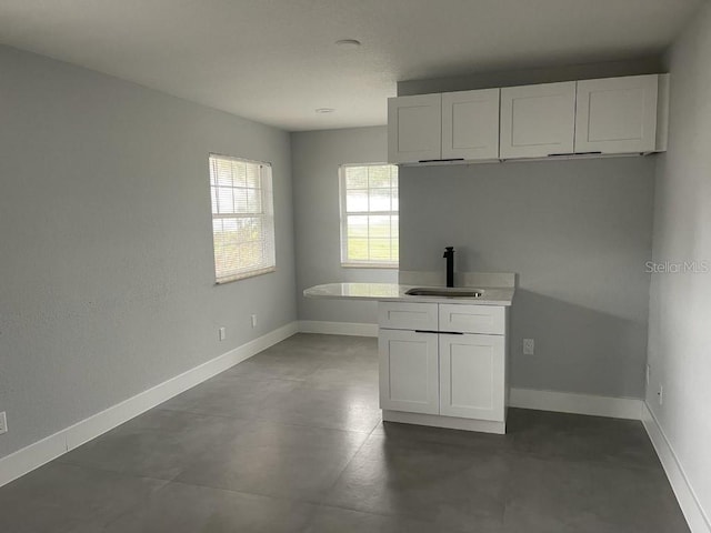 kitchen with white cabinets, sink, and tile floors