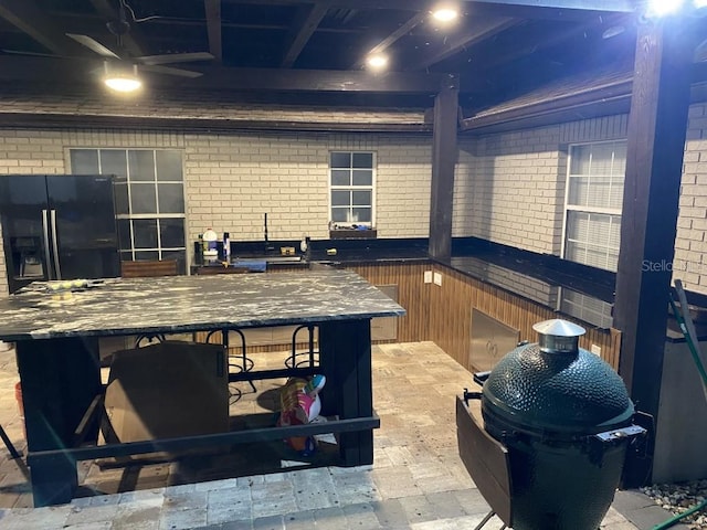 interior space featuring brick wall and ceiling fan