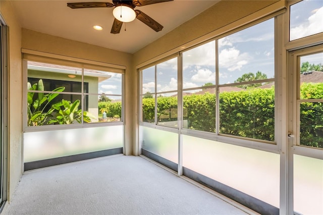 unfurnished sunroom with ceiling fan