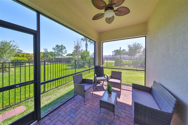 sunroom / solarium featuring ceiling fan