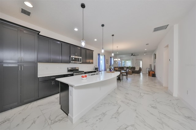 kitchen featuring ceiling fan, hanging light fixtures, sink, an island with sink, and stainless steel appliances