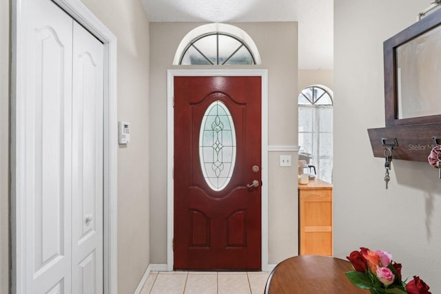 foyer with light tile patterned floors and a textured ceiling