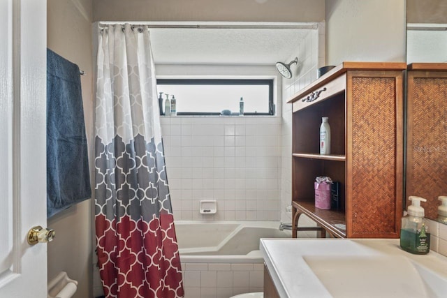 full bathroom featuring sink, shower / bath combo, toilet, and a textured ceiling