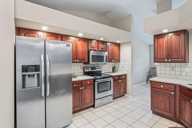 kitchen featuring appliances with stainless steel finishes, tasteful backsplash, lofted ceiling, and light tile patterned flooring