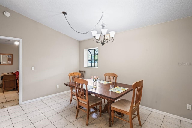 dining space featuring light tile patterned floors, a textured ceiling, and a notable chandelier