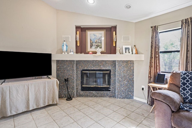 living room with a fireplace, light tile patterned flooring, and lofted ceiling