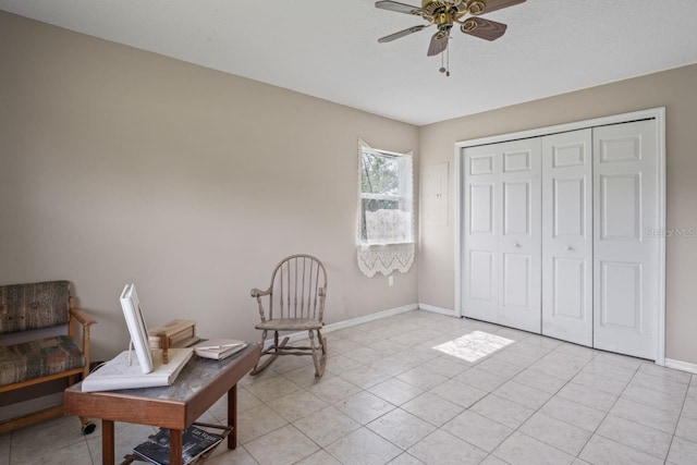 living area featuring light tile patterned floors and ceiling fan