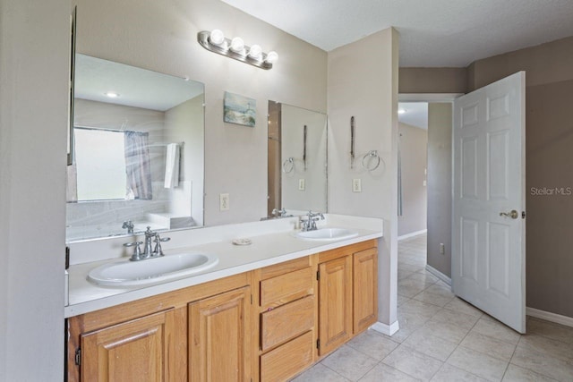 bathroom with tile patterned floors, vanity, and a textured ceiling