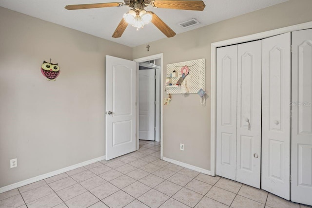 unfurnished bedroom with ceiling fan, a closet, and light tile patterned flooring