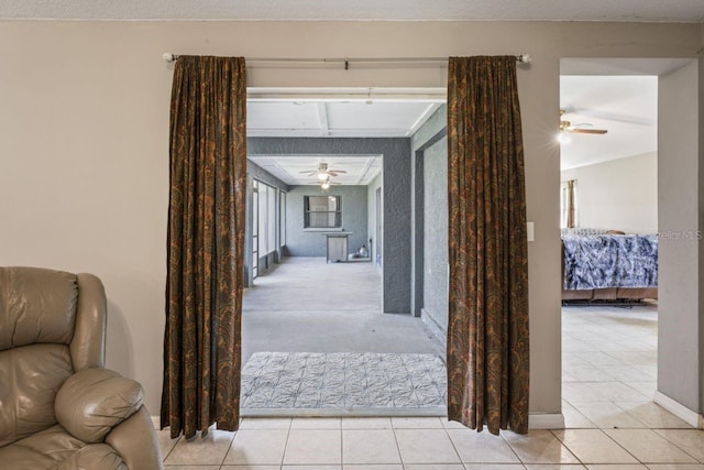 hallway featuring light tile patterned floors and lofted ceiling