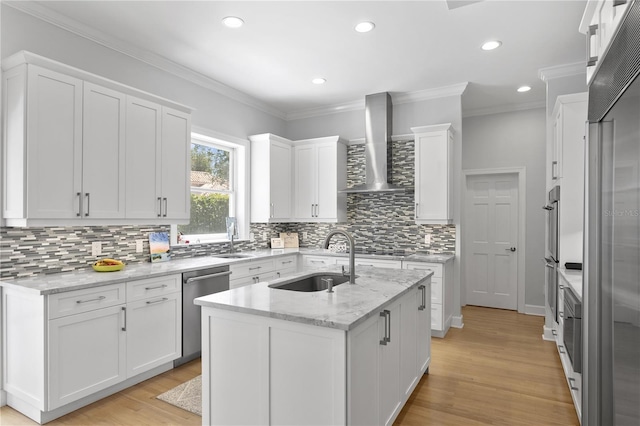 kitchen with appliances with stainless steel finishes, wall chimney range hood, light wood-type flooring, and light stone countertops