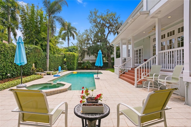 view of pool with a patio area and an in ground hot tub