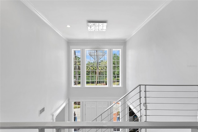 stairway featuring a notable chandelier and crown molding