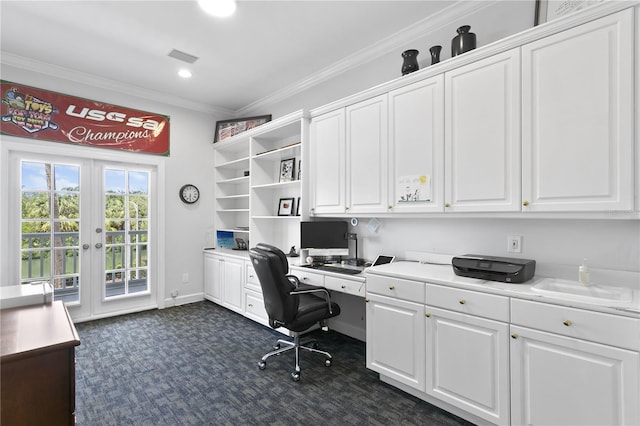 office with built in desk, dark colored carpet, crown molding, and french doors