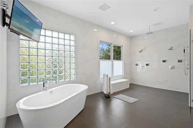 bathroom featuring independent shower and bath, tile floors, and tile walls