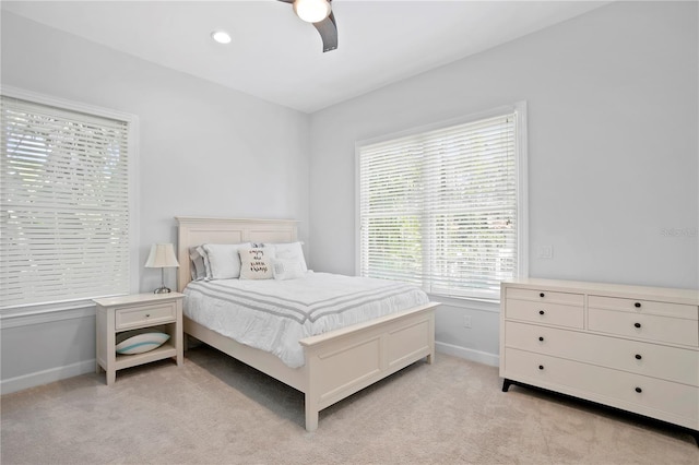 carpeted bedroom with ceiling fan and multiple windows