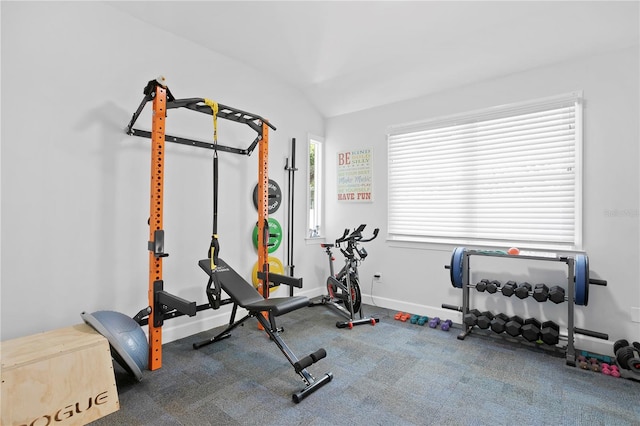 workout room featuring dark colored carpet and lofted ceiling