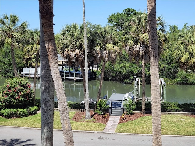 dock area with a lawn and a water view