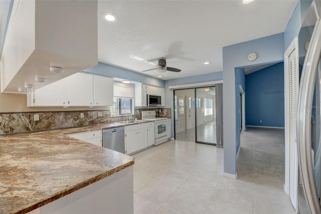 kitchen with backsplash, sink, ceiling fan, appliances with stainless steel finishes, and white cabinetry