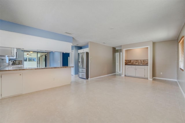 unfurnished living room with a textured ceiling and sink