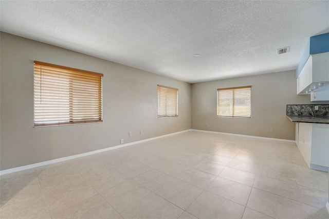 unfurnished room featuring light tile patterned floors and a textured ceiling