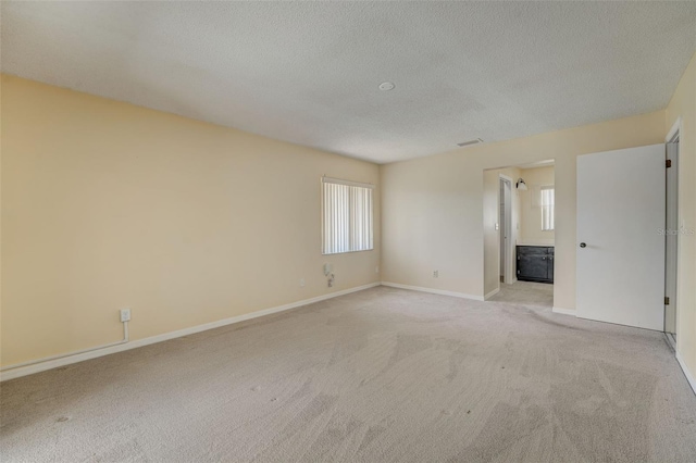 carpeted spare room featuring a textured ceiling