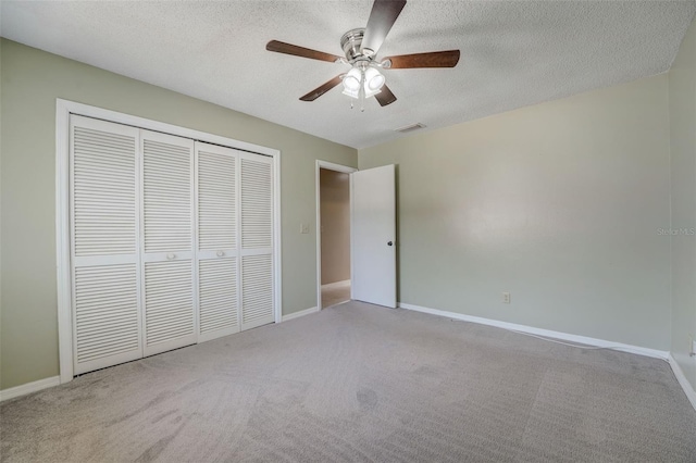 unfurnished bedroom featuring a textured ceiling, ceiling fan, light carpet, and a closet