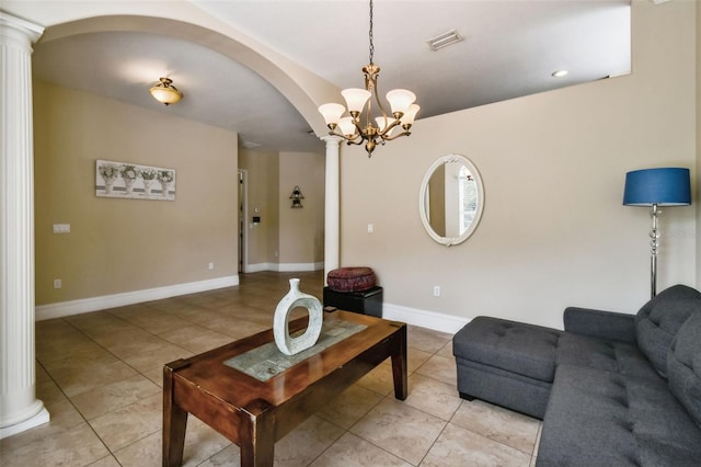 living room with light tile flooring, a chandelier, and decorative columns